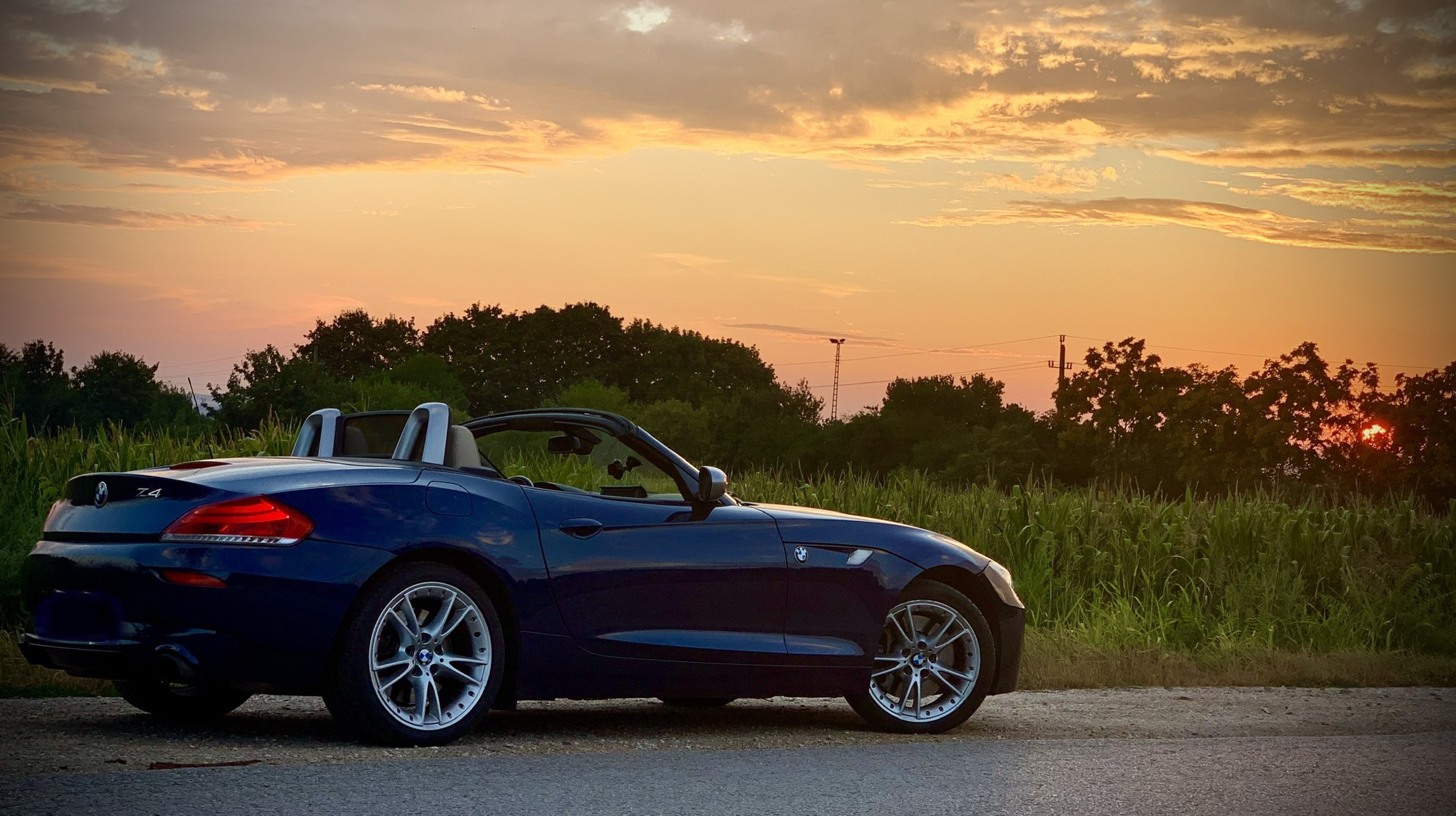 Mélykék BMW Z4 nyitott tetővel a naplementében